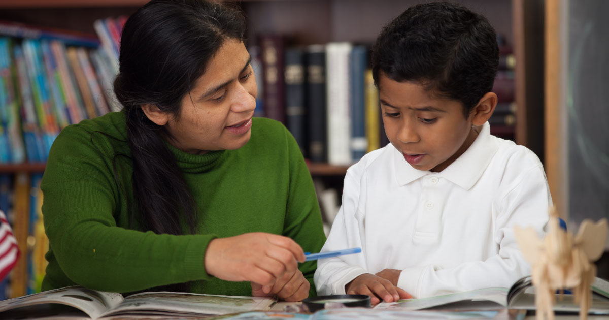 Multilingual student reading to teacher